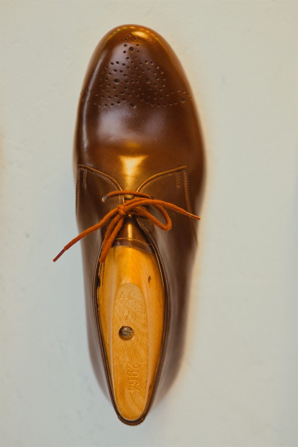 Maßschuh auf seinem hölzernen Leisten, geschnürt zur Anprobe